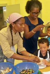 Chef Evelyn Paul (left), Annette Carrington, and Keoni Riggs make wraps.